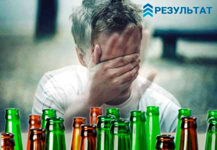 Алкоголик перед пустыми бутылками в состоянии похмелья
